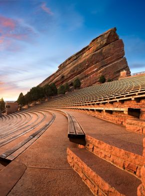 Sunset view of the Red Rocks Amphitheatre with empty seating and dramatic red rock formations in the background near The Windsor luxury apartments.