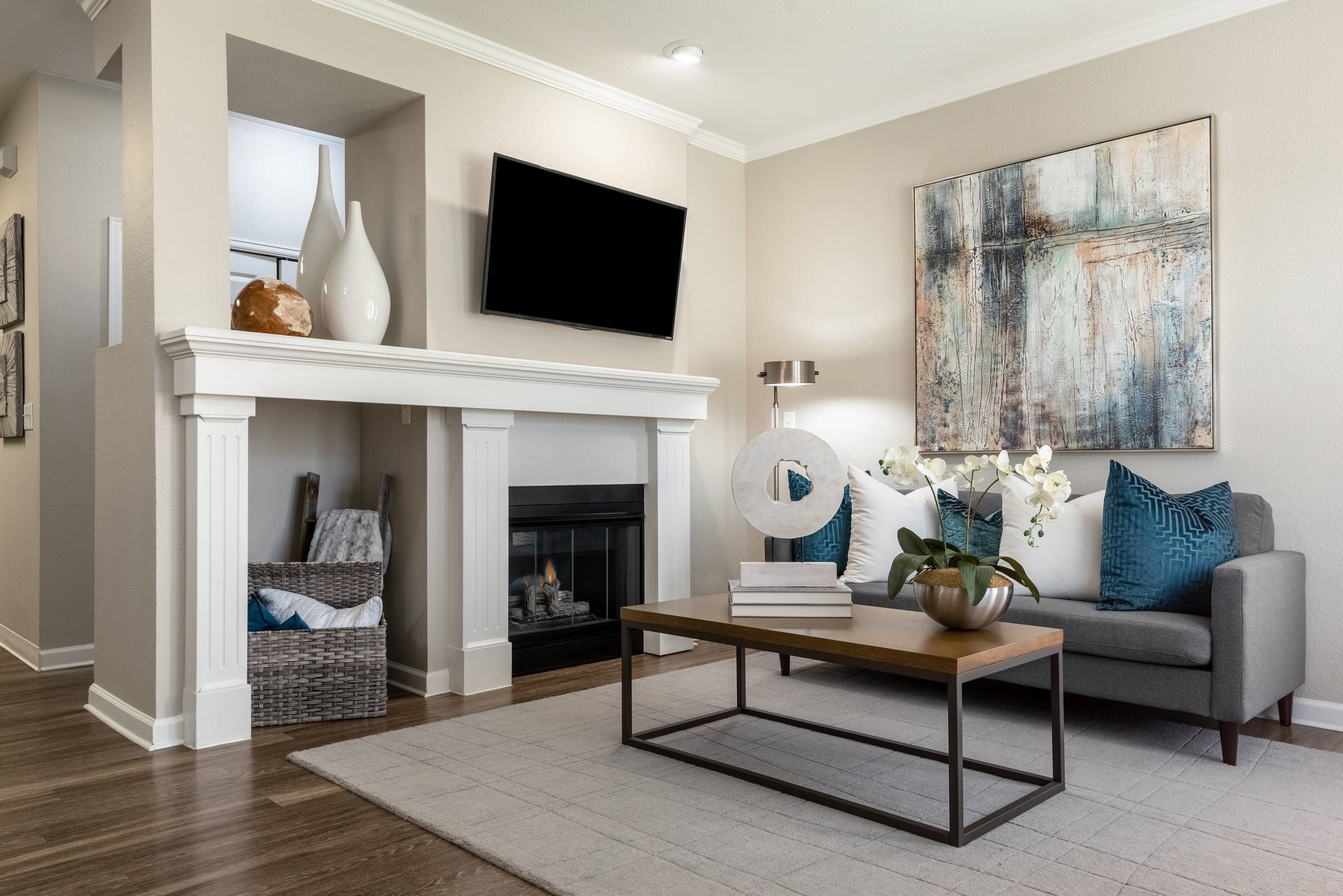 The Windsor living room with fireplace and large tv furnished with couch and coffee table